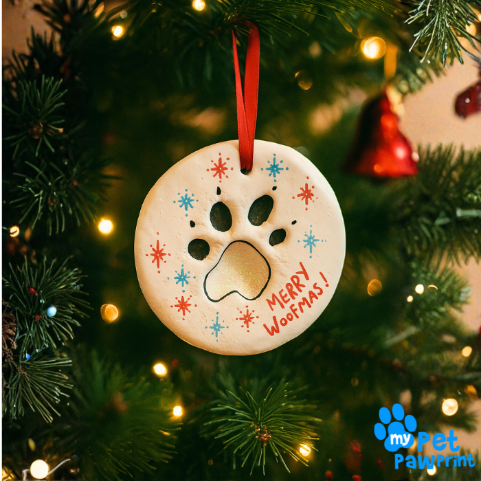Decorative Christmas ornament with paw print and 'Merry Wootmas!' text on a tree.